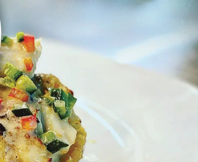 A plated dish with diced pepper and courgette relish on a white plate.